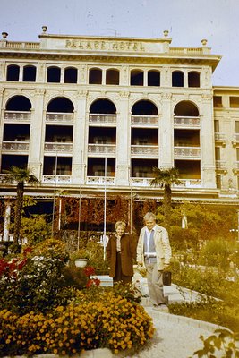 Neoclassical **Palace Hotel** façade with arched balconies and ornate cornices, likely from the **1960s-70s**. Two individual...