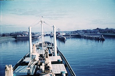 Vintage black-and-white photo of a mid-20th-century ferry docked at a pier, likely in a coastal European port. The vessel’s o...
