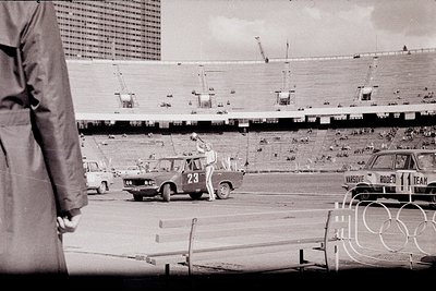 A driver in a distinctive blue sedan, marked "Varsovie Rodeo" and bearing the number 23, participates in an automobile stunt ...