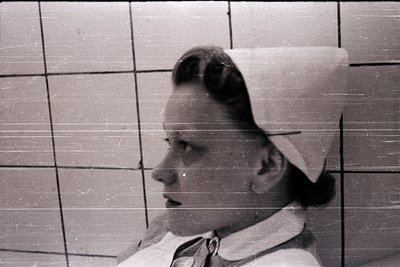 Nurse in classic 1950s-60s cap and uniform, profile view against tiled wall. Mid-century medical aesthetic with clean, struct...
