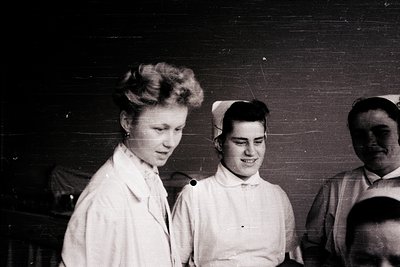 Black-and-white photo of two women in early 20th-century nursing uniforms, likely 1920s–1940s. One wears a cap with a brim; b...