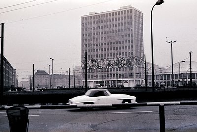 Mid-century Brutalist high-rise with decorative mosaic facade, likely a government or cultural building. Urban street scene w...