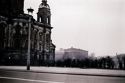 Historic black-and-white photo of a grand **Neoclassical-style building** with ornate columns and a prominent **bell tower**....