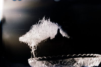 Vintage close-up of a snowflake on a glass surface, captured in monochrome. The intricate crystalline structure contrasts aga...