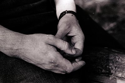 Close-up of two hands clasped in a gesture of support or intimacy, likely mid-20th century based on vintage monochrome style....