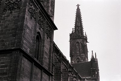 Gothic cathedral spire with intricate stone tracery and pointed arches, likely 14th–16th century European. Ornate facade deta...