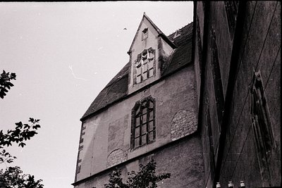Gothic-style timber-framed building with exposed beams and diamond-patterned infill, featuring a steep gable roof and a small...
