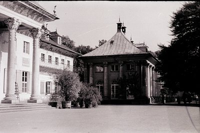 Neoclassical courtyard building with domed pavilion, likely 19th-century European. Symmetrical columns, arched windows, and o...