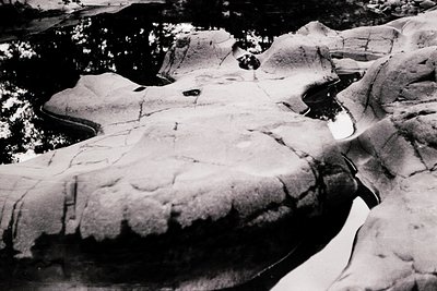 Black-and-white aerial view of rugged, eroded rock formations resembling abstract organic shapes. Likely a mid-20th century g...
