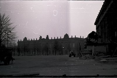 Vintage black-and-white photo of a grand, symmetrical neoclassical building with columns and a pediment, likely a palace or g...