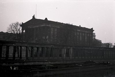 Neoclassical building with grand columns and a flat roof, likely a railway station or public edifice, photographed in black-a...