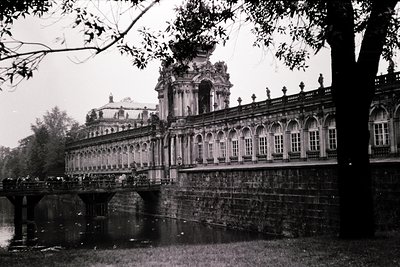 Baroque-style palace with arched colonnade and central dome, likely **Sofia’s Royal Palace** (). Stone bridge spans a reflect...