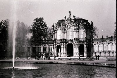Baroque-style palace façade with ornate sculptures, arched windows, and a central fountain in a grand courtyard. Likely 18th-...