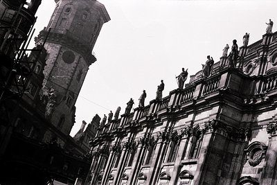 Gothic-style stone façade with ornate balustrade featuring 12 statues, likely part of a European cathedral or town hall. The ...