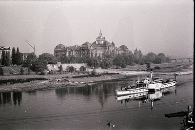 Historic riverside building with ornate towers and mansard roofs, likely a 19th-century institutional or governmental structu...