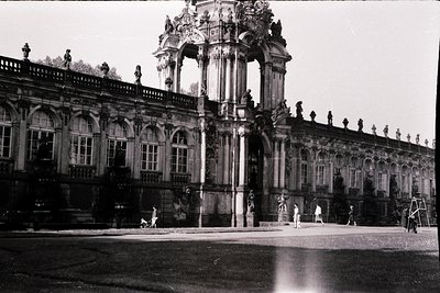 Baroque palace façade with ornate columns and statues, likely **Sanssouci Palace, Potsdam, Germany**. Central grand staircase...