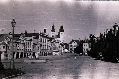 Vintage black-and-white street scene featuring early 20th-century European architecture. Prominent arched buildings with dome...