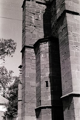 Historic brick tower with weathered, rectangular buttresses supporting a corbelled parapet. Likely 19th-century industrial or...