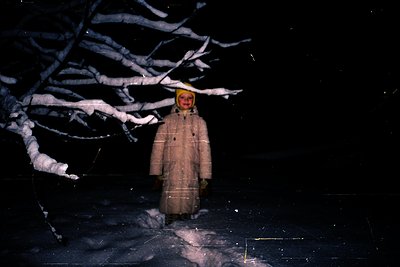 Winter portrait of a child in a snowy forest, standing on ice. The vintage sepia tone suggests 1960s–1970s photography. Heavy...