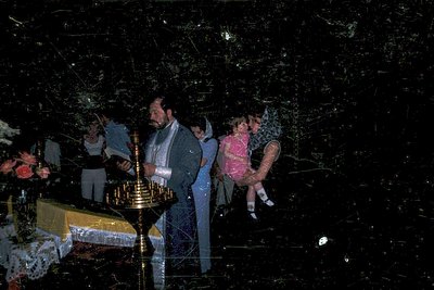 Vintage Orthodox Christian baptism ceremony with priest holding a golden censer. Two children in traditional white baptismal ...