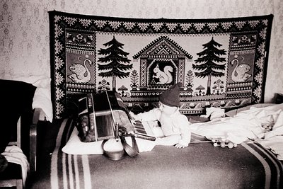 Vintage black-and-white interior featuring a handwoven wall hanging with symmetrical pine trees, deer, and geometric motifs. ...