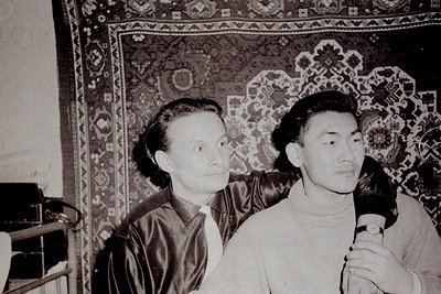 Black-and-white portrait of two men in formal attire, likely 1950s–1960s. Left: man in dark suit with tie; right: man in ligh...