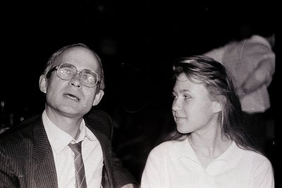 Black-and-white portrait of a man in round glasses and a suit, alongside a woman in a white blouse, likely from the 1970s–198...