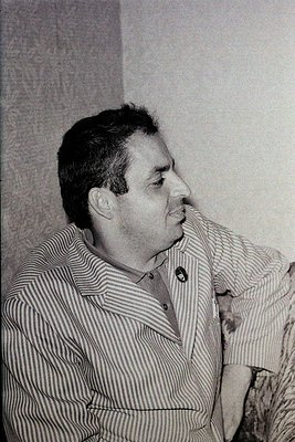 Portrait of a man in a striped button-up shirt, mid-20th century style, likely –. Plain background suggests studio or formal ...