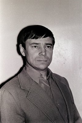 Portrait of a man in a mid-century suit, likely 1960s–1970s. Plain background suggests studio or formal setting. Clean, angul...