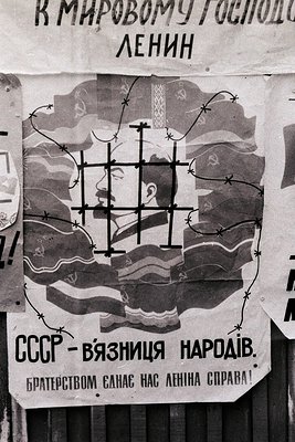 Vintage Soviet-era poster depicting Lenin’s face behind barbed wire, symbolizing imprisonment of nations. Text reads: *"СССР ...