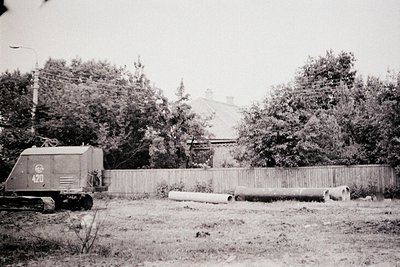 Vintage black-and-white photo of a Soviet-era military truck (ZIS-151 or similar) marked "420" parked beside a wooden fence. ...
