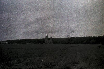 Vintage black-and-white photo of a grand Baroque-style church with twin towers and a central dome, set against a stormy sky. ...