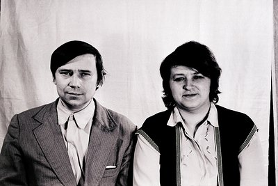 Portrait of two individuals in formal attire, likely from the 1970s–1980s. The man wears a suit with a white dress shirt and ...