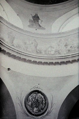 Fresco fragment depicting religious iconography: central figure in haloed robe, flanked by smaller scenes of saints or apostl...
