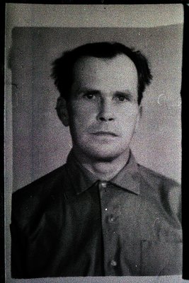 Mid-century black-and-white portrait of a man in a plain collared shirt, likely a 1950s–1960s identification or passport phot...