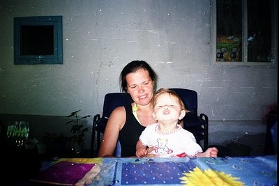 Indoor portrait of a woman and young child sharing a joyful moment, likely mid-1990s to early 2000s. Woman in a sleeveless bl...
