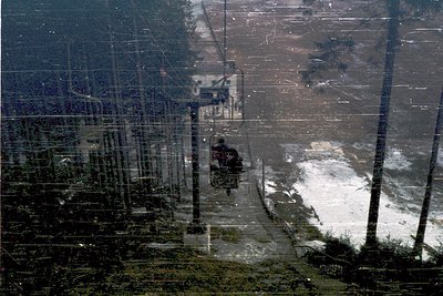 Aerial view of a coastal industrial zone with a mix of infrastructure and natural elements. Visible: concrete structures, uti...