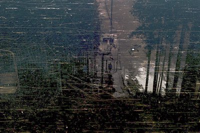 Aerial view of a flooded forest landscape, likely post-storm or seasonal inundation. Water covers dense tree clusters, with v...