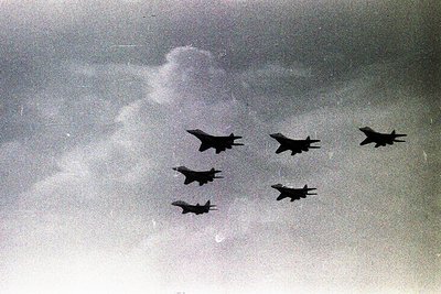 Five jet aircraft in tight formation against a cloudy sky, likely mid-20th century military jets. Formation suggests training...