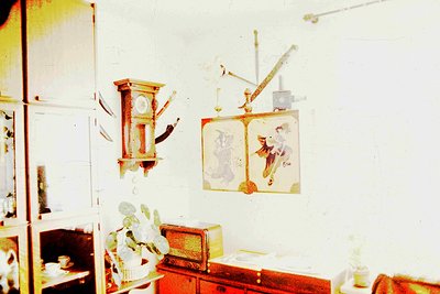 Vintage interior featuring a wooden grandfather clock with ornate carvings and a decorative wall clock. Below, a vintage suit...