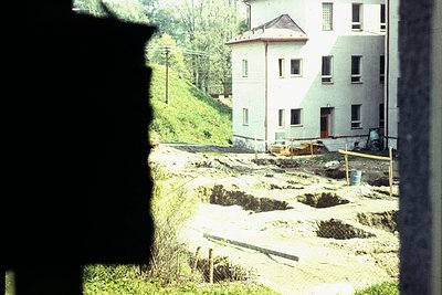 Vintage 2-story building under construction, featuring exposed brick foundation and wooden scaffolding. Yellow construction e...