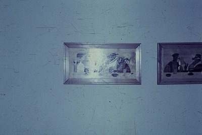 Vintage framed photographs mounted on a textured wall, likely from the mid-20th century. Left frame shows a blurred but recog...
