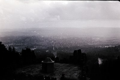 Vintage black-and-white aerial view of a sprawling urban landscape with dense residential clusters and a prominent central to...