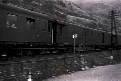 Mid-20th century passenger train in motion, likely European. Streamlined carriages with rounded edges, visible "S" marking on...
