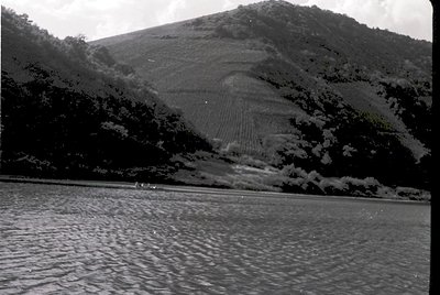 Terrace farming carved into a steep hillside, likely rice paddies, with water reflecting the landscape. Black-and-white vinta...