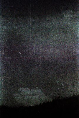 Vintage black-and-white astronomical photo of a starry night sky with a faint, vertical light streak (likely a meteor or came...
