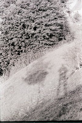 Vintage aerial view of eroded, barren terrain with distinct, irregularly shaped depressions—likely salt pans or dried lakebed...