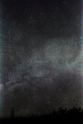 Vintage sepia-toned photograph with heavy grain, likely early 20th century. Faint vertical lines suggest a damaged or aged pr...