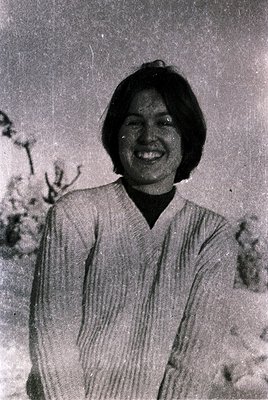 Portrait of an individual in a vintage-style striped blouse, likely mid-20th century. The hairstyle and clothing suggest East...