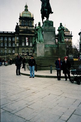 Historic equestrian statue in Prague’s Wenceslas Square, flanked by bronze figures, set against neoclassical National Museum ...